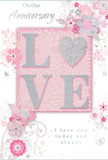 This anniversary card presents a softly romantic design, capturing the feeling of an intimate celebration at home in Archway with flowers on the table and warm light in the room. In the centre, the word LOVE stands out in raised, glittered letters, combining blush pink, milky white, and light silver tones that shimmer gently when viewed from different angles. The textured finish invites the fingertips, suggesting the same tactile pleasure as brushing past velvety rose petals in a carefully crafted bouquet. The letters rest against a serene backdrop of pastel pink, subtly shaded to add a sense of depth, like a delicate wash of watercolour. Flowing out from behind the word, an array of illustrated blooms and curling tendrils stretches across the card, their fine outlines picked out in pale grey and blush, with highlights of metallic silver adding a touch of celebration. The flowers are stylised and graceful, resembling simple roses or mixed garden blossoms rendered by a florist with a sketchbook open on Junction Road. Leaves and swirls overlap and weave together, suggesting the light movement of foliage in a gentle breeze. Small flourishes-tiny petals, loops, and curving stems-soften the edges and create a sense of continuous flow. An anniversary message, such as On Our Anniversary or I love you today and always, appears in an elegant script font, carefully placed so it feels naturally integrated into the floral artwork. The overall impression is one of trusted affection and enduring partnership, like a cherished routine of exchanging flowers and cards each year, with this design reflecting both tenderness and quiet sophistication in Archway.